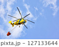 Helicopter operates above the clouds, transporting water in a bold firefighting mission 127133644