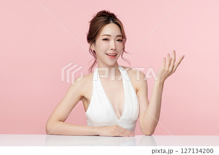 A beautiful young Asian woman with clean, fresh skin against a pink background. Skincare, facial treatment, cosmetology, beauty, and spa. An elegant portrait of an Asian woman. A beautiful young Asian woman with clean, fresh skin against a pink background. Skincare, facial treatment, cosmetology, beauty, and spa. An elegant portrait of an Asian woman. 127134200