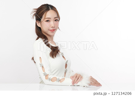 A beautiful young Asian woman with clean, fresh skin against a white background. Skincare, facial treatment, cosmetology, beauty, and spa. An elegant portrait of an Asian woman. 127134206