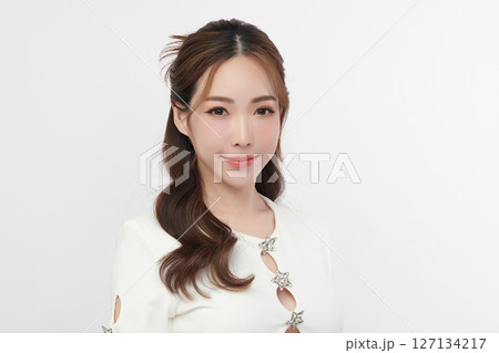 A beautiful young Asian woman with clean, fresh skin against a white background. Skincare, facial treatment, cosmetology, beauty, and spa. An elegant portrait of an Asian woman. 127134217