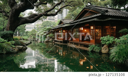 Japanese garden: traditional house, lush greenery, serene pond reflecting nature and architecture. Beautiful Japanese culture scene 127135108