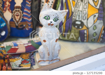 Wooden cat figurine in shop window. Handcrafted toy and folk art concept. 127135200