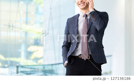 スマートフォンで通話をする笑顔の男性ビジネスマン 127136186