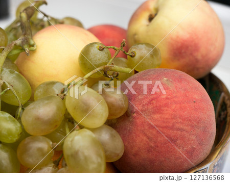 Still life of grapes and peaches in a plate. Still life of grapes and peaches in a plate. 127136568