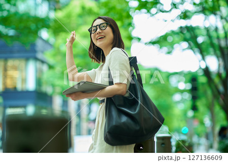 街角で手を振る女性 127136609