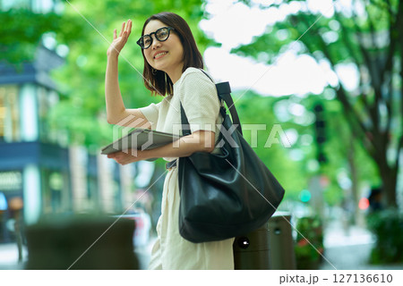 街角で手を振る女性 127136610
