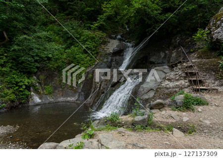 An observation deck near a small waterfall in the mountains of Georgia 127137309