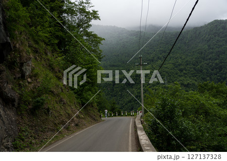 The road leading down. Incredible view of the mountains, clouds in the mountains 127137328