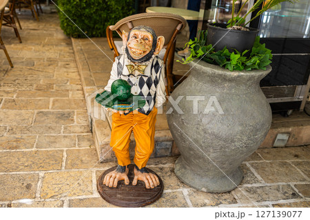 Funny monkey statue outside a cafe. Humor, street decor, and quirky visual marketing. Copy space Funny monkey statue outside a cafe. Humor, street decor, and quirky visual marketing. Copy space 127139077