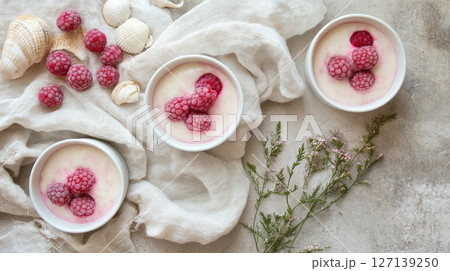 Beach picnic with berry tiramisu in cups, seashells and linen napkins, coastal summer mood Beach picnic with berry tiramisu in cups, seashells and linen napkins, coastal summer mood 127139250