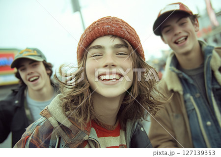 Teenagers enjoying a joyful moment while jumping and laughing on a vibrant street 127139353