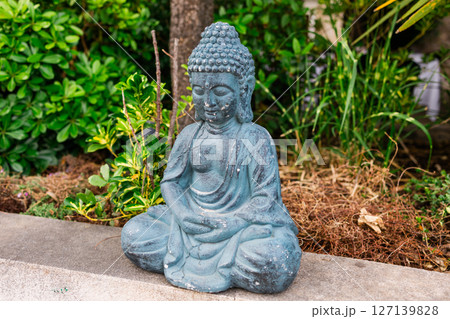 Buddha statue on a table in a peaceful outdoor cafe. Meditation, serenity, and spiritual decor in public space. Buddha statue on a table in a peaceful outdoor cafe. Meditation, serenity, and spiritual decor in public space. 127139828