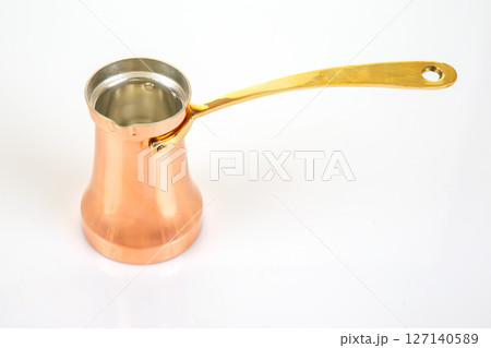 traditional copper Turkish coffee pot with a long brass handle, isolated on a white background 127140589