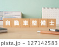 自動車整備士と書かれたブロックが置かれたデスク 127142583