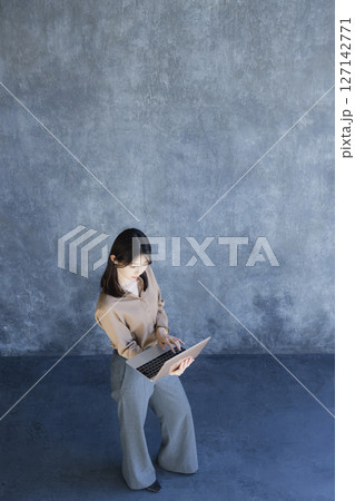 ノートパソコンを持って立っている女性 ノートパソコンを持って立っている女性 127142771