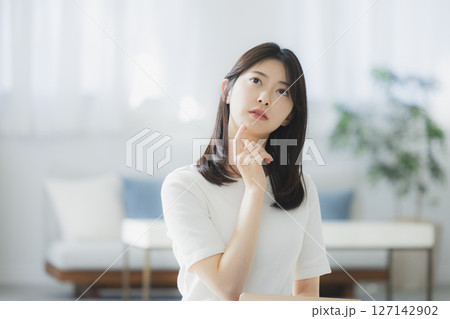 部屋で考え事をする若い女性 127142902