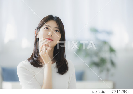 部屋で考え事をする若い女性 部屋で考え事をする若い女性 127142903