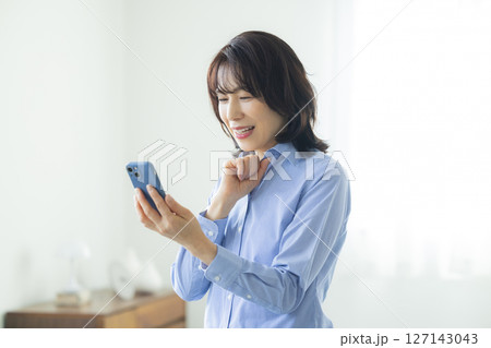 リビングでスマホを使う女性 127143043
