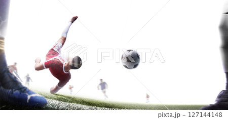A footballer performs a powerful overhead kick while falling. Soccer action game. Isolated. Rear view 127144148