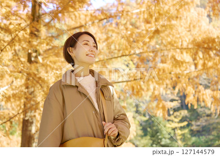 秋の紅葉の中を散歩する女性　ミドルエイジ 127144579