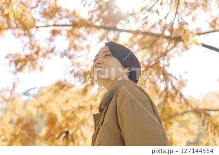 秋の紅葉の中を散歩する女性　ミドルエイジ 127144584