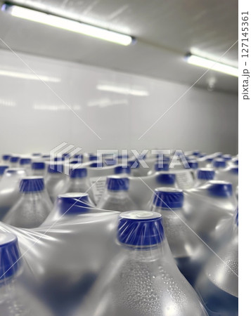 water bottles lined up for delivery in warehouse environment during daytime hours. closeup. water bottles lined up for delivery in warehouse environment during daytime hours. closeup. 127145361