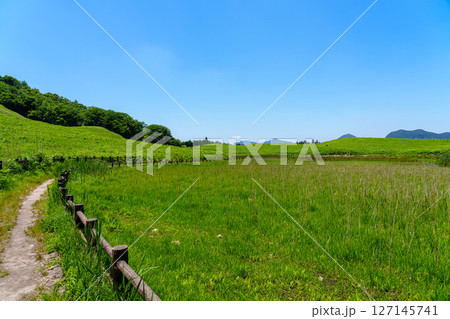 初夏の曾爾高原　お亀池周囲もめぐる南側遊歩道から見た風景　入り口へ続く遊歩道と曽爾の山並み 127145741