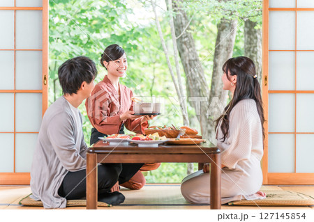 温泉旅館の客室でお茶を淹れる旅館スタッフ・仲居さんの女性 温泉旅館の客室でお茶を淹れる旅館スタッフ・仲居さんの女性 127145854