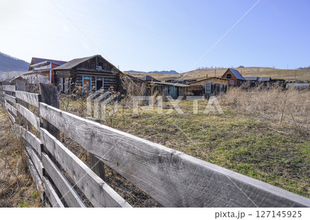 A street with an abandoned dilapidated house with antique window frames in Gorny Altai A street with an abandoned dilapidated house with antique window frames in Gorny Altai 127145925
