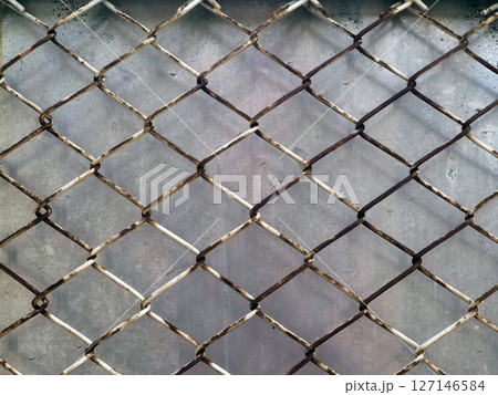 A mesh wire with diamond shape, showing strength with unique design, against textured grey background 127146584