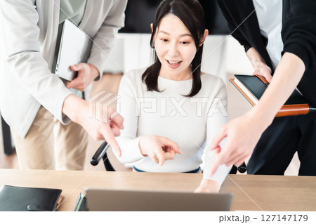 パソコンを囲み協議する仲の良いビジネスチーム パソコンを囲み協議する仲の良いビジネスチーム 127147179
