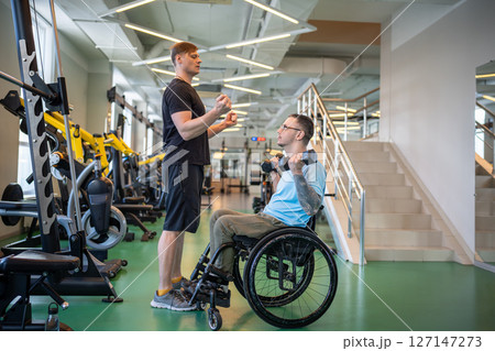 Coach guides disabled athlete through weightlifting workout focusing on technique and execution 127147273