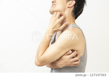 身体を掻く男性　白バック 127147303