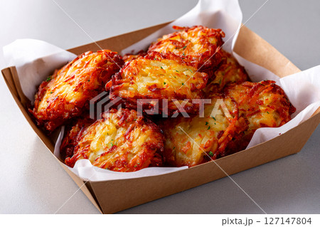 Hashbrowns in soft daylight, white backdrop, minimalist corner, styled in clean photo fashion 127147804