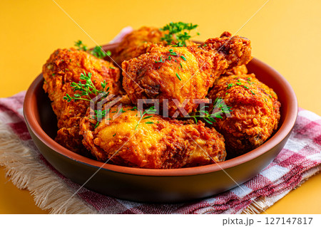 Southern fried chicken glows in golden hour light, rustic corner, pastel yellow backdrop, clean style 127147817