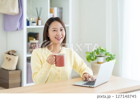リビングでパソコンを使う若い女性 127148745