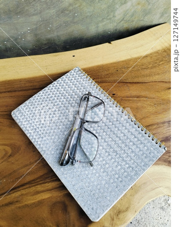 Notebook with pen and glasses on wooden table. professional workspace organization. Top view 127149744