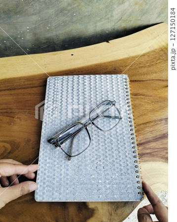 Notebook with pen and glasses on wooden table. professional workspace organization. Top view Notebook with pen and glasses on wooden table. professional workspace organization. Top view 127150184