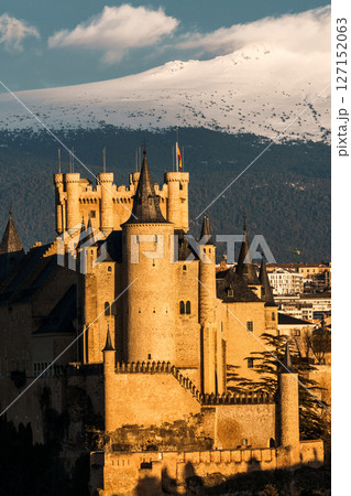 The Alcazar of Segovia stands majestically against the Guadarrama mountains in Spain. 127152063