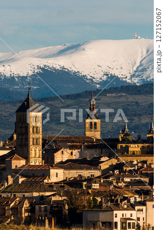 Segovia cityscape, with the iconic tower rising against the snowy Guadarrama mountains. 127152067