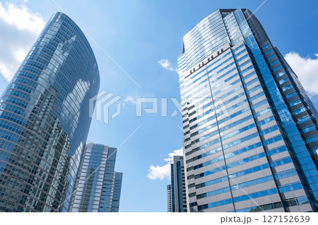 雲が窓ガラスに映り込む青空に映える高層ビル 127152639