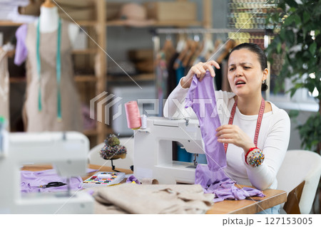 Asian dressmaker working with fabric 127153005