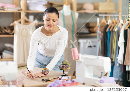 Asian dressmaker draws patterns with curved rulers Asian dressmaker draws patterns with curved rulers 127153007