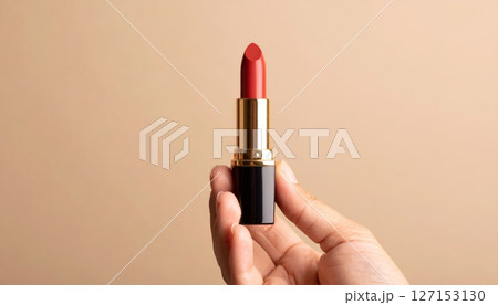 Woman's hand applying red lipstick, a classic beauty accessory for a touch of glamour and style 127153130