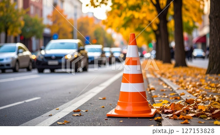 Orange traffic cones line an urban asphalt road, guiding direction and ensuring safety amidst city transportation Orange traffic cones line an urban asphalt road, guiding direction and ensuring safety amidst city transportation 127153828