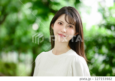 新緑の中で振り向く女性 127153982