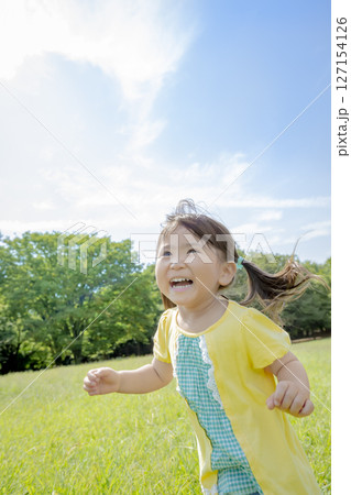 公園の草地で遊ぶ女の子 127154126
