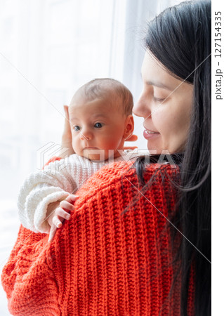 Tender Moment Between Mother and Baby by the Window 127154335