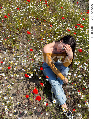Woman Relaxing in a Field of Wildflowers Woman Relaxing in a Field of Wildflowers 127154355