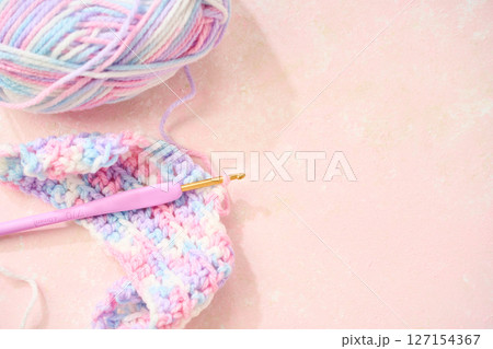 パステルカラーの毛糸でかぎ針編みをする編み物のイメージ 127154367